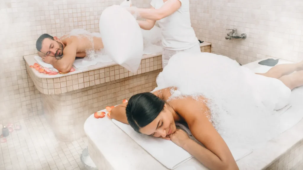 Therapist performing kese exfoliation in Turkish bath