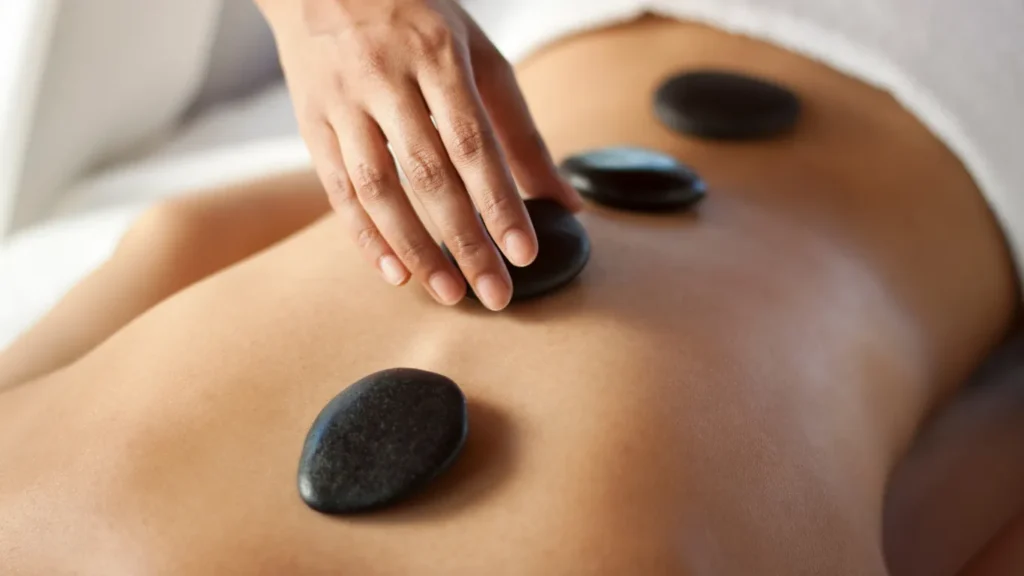 Therapist performing hot stone massage as part of spa package